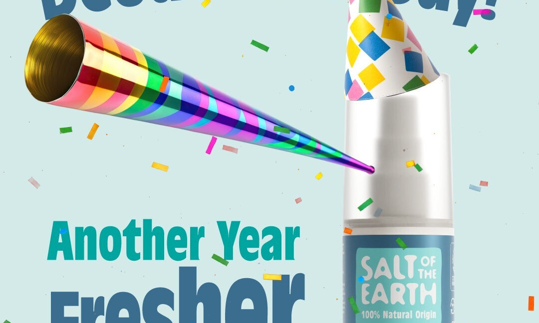 Salt of the Earth Ocean & Coconut refillable spray deodorant wearing a party hat with confetti and party blower, celebrating National Deodorant Day with the text ‘Happy National Deodorant Day! Another Year Fresher