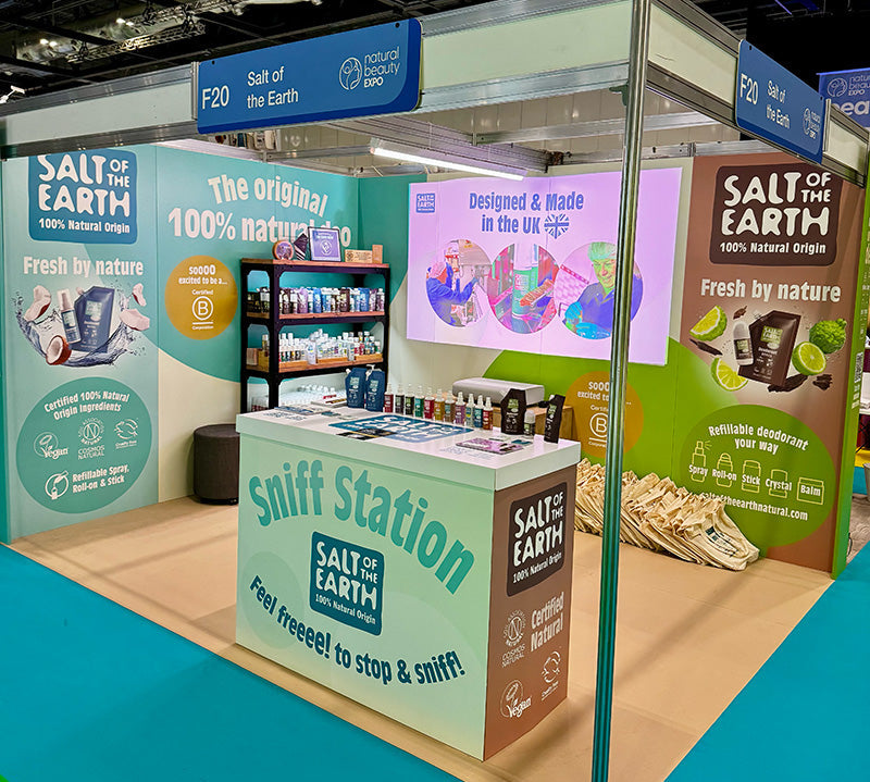 Salt of the Earth completed exhibition stand at NOPE 2025, featuring cardboard display panels, our sniff station, product shelving, certification logos, and 100% natural origin messaging alongside our B Corp certification.