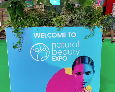 Empty Salt of the Earth natural deodorant exhibition stand F20 at Natural Beauty Expo before setup, showing the white shell scheme booth with blue branded header panels.